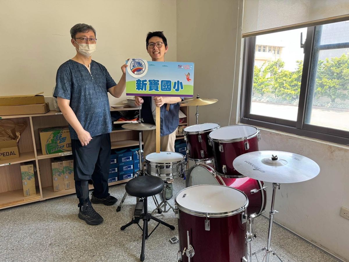 Principal Fang with a donated drum kit for the school · 方順陽校長與校方獲贈的爵士鼓組