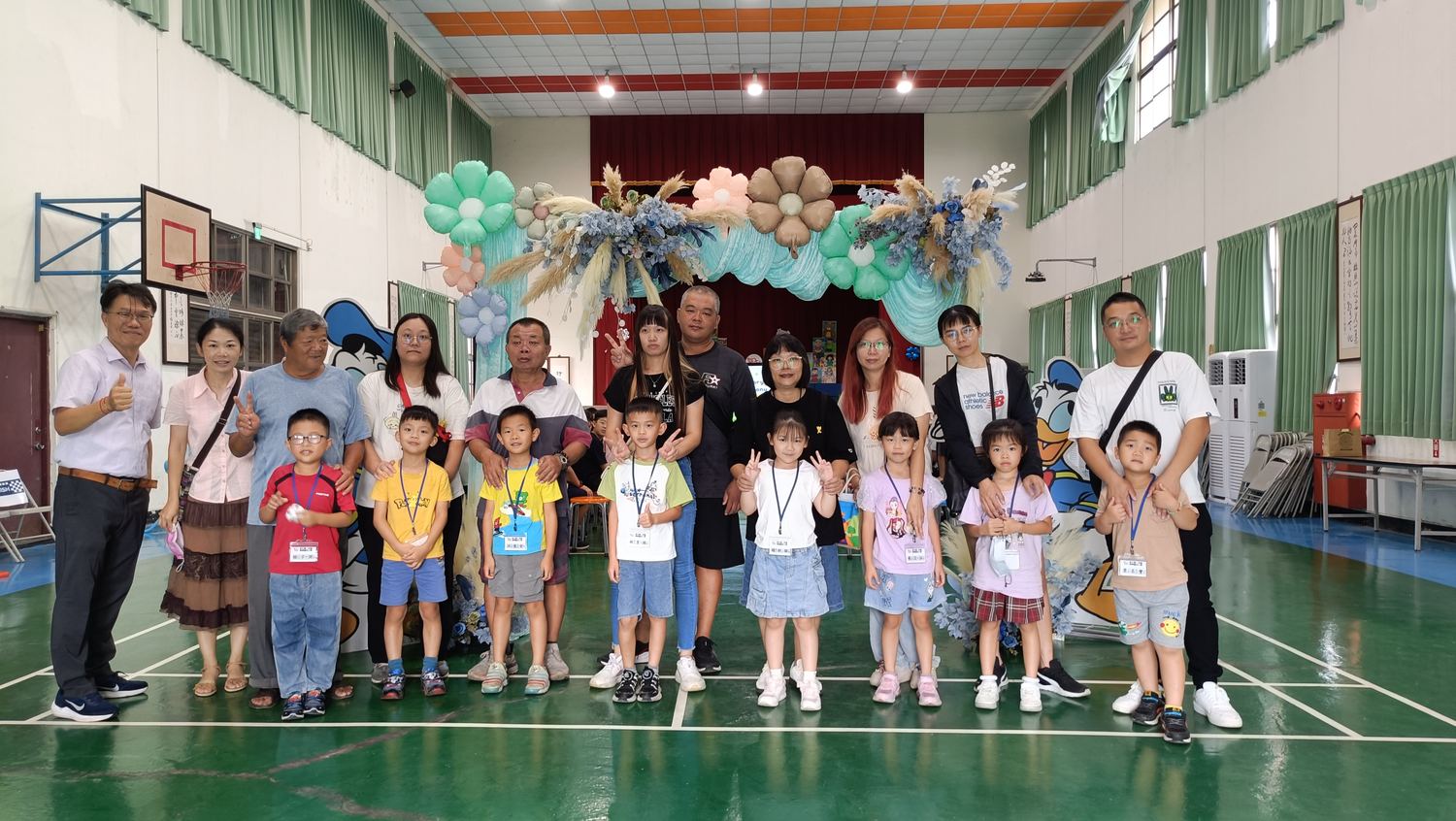 興華國小師長與小一新生在禮堂合照 Teachers and new first graders in a group photo in the school hall