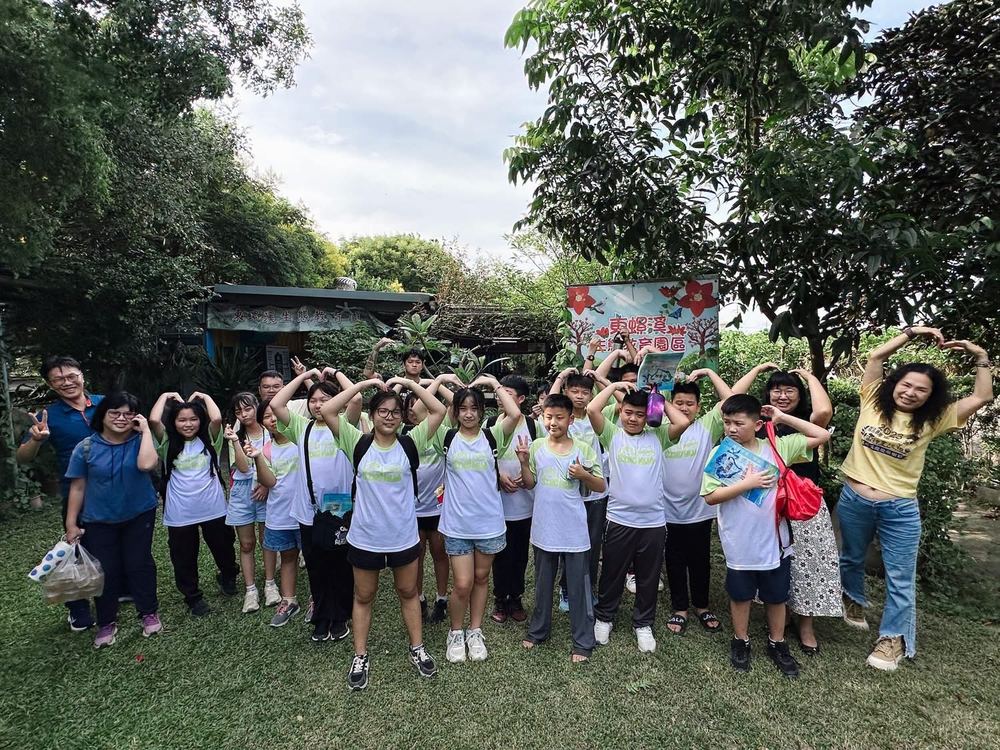 六年甲班師生在生態園區比愛心合照 Class 6A and their teachers making heart shapes in a group photo at the ecology park