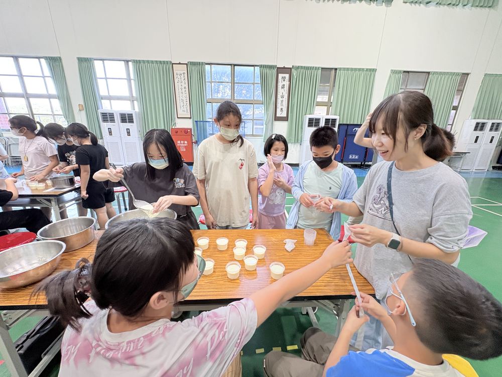 學生把奶酪倒進小杯子裡 Students pouring panna cotta into small cups