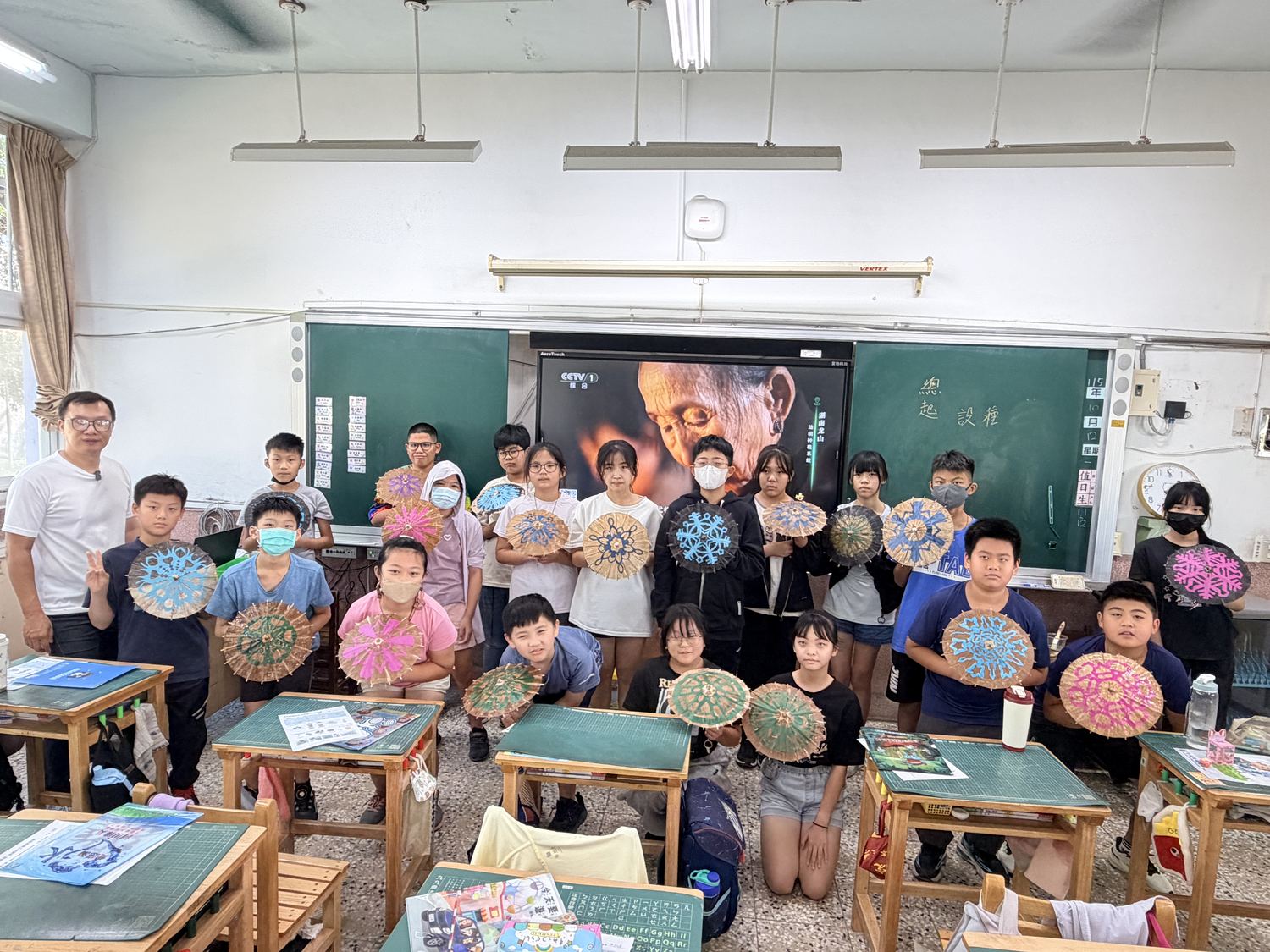 六年甲班學生拿著貼上窗花的傘在教室合照 Class 6A holding up their umbrellas decorated with paper cuttings in a class photo