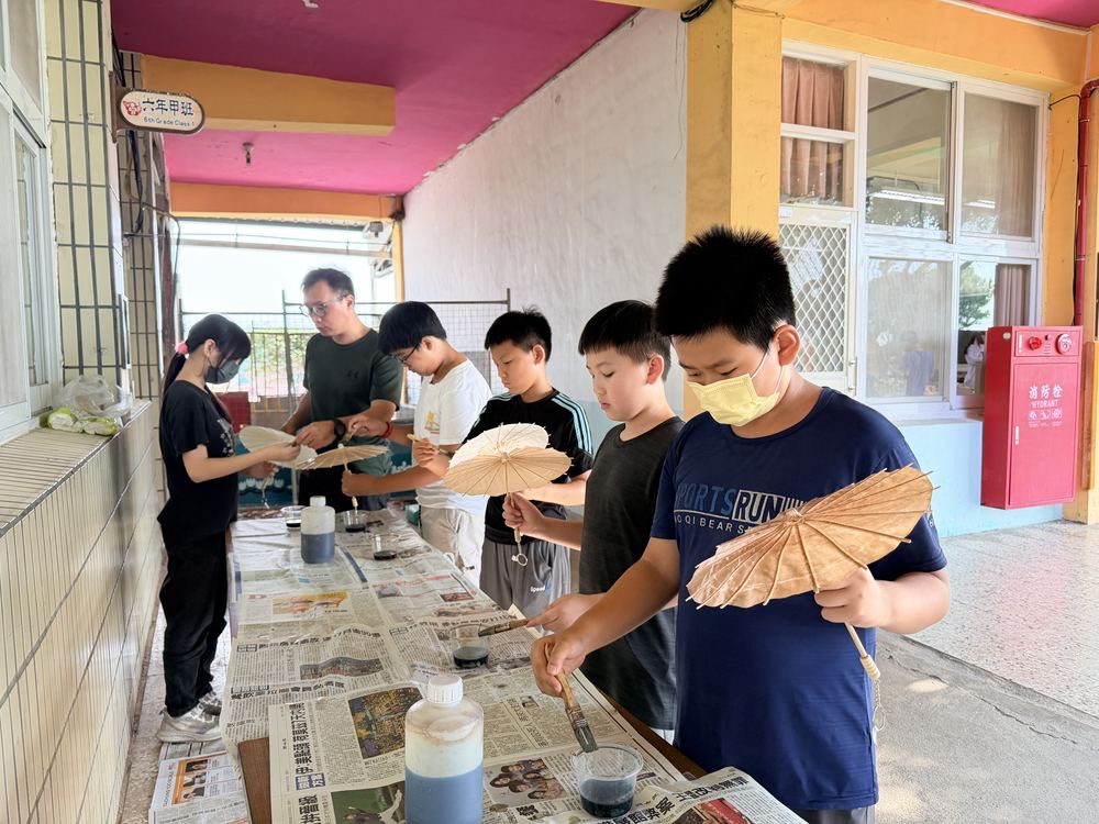 學生在走廊桌上製作傘面 Students working on their umbrellas at tables in the hallway