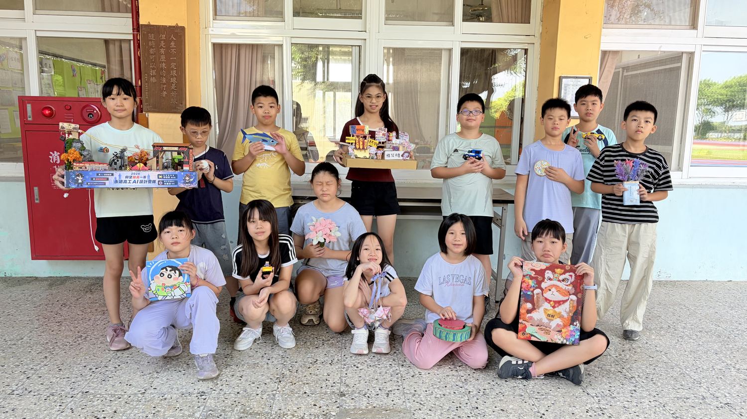 學生拿著自己的暑假作品在走廊合照 Students holding up their summer projects in a group photo in the hallway