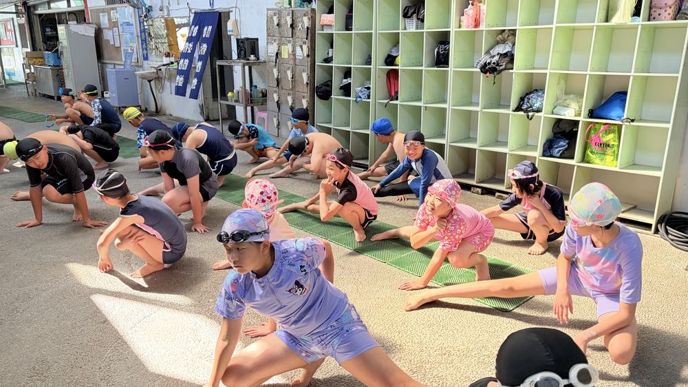 學生在泳池邊做暖身操 Students warming up on the pool deck