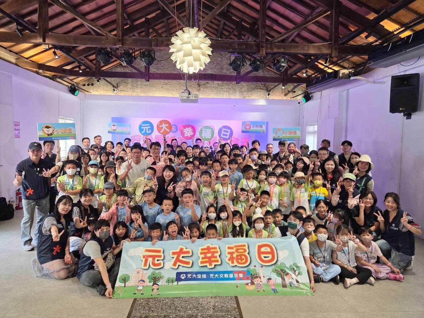 元大幸福日活動大合照，前方拿著「元大幸福日」布條 A big group photo at Yuanta Happiness Day, with the event banner in front