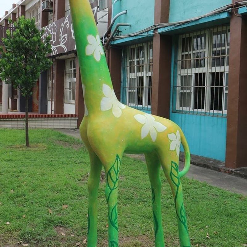 興華國小草地上的綠色彩繪長頸鹿雕塑 A green painted giraffe sculpture on the SingHua lawn
