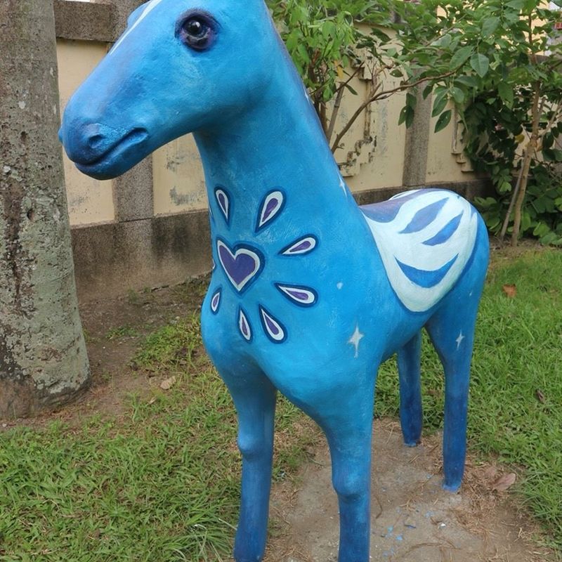 興華國小的藍色彩繪小馬雕塑，身上有愛心圖案 A blue painted horse sculpture with a heart pattern at SingHua