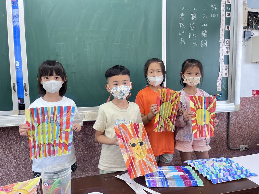 興華國小繪畫社學生拿著色彩繽紛的作品合照 SingHua Art Club students holding up their colorful artwork