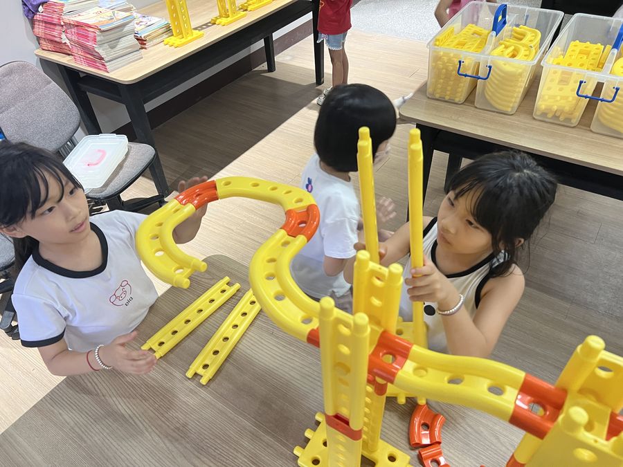 興華國小學生用黃色與橘色的科學積木組裝結構 SingHua students building a structure with yellow and orange science blocks