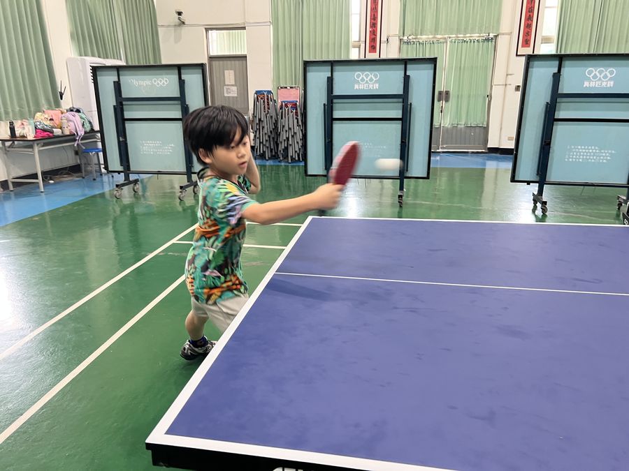 興華國小桌球社學生揮拍擊球 A SingHua Table Tennis Club member swinging at the ball