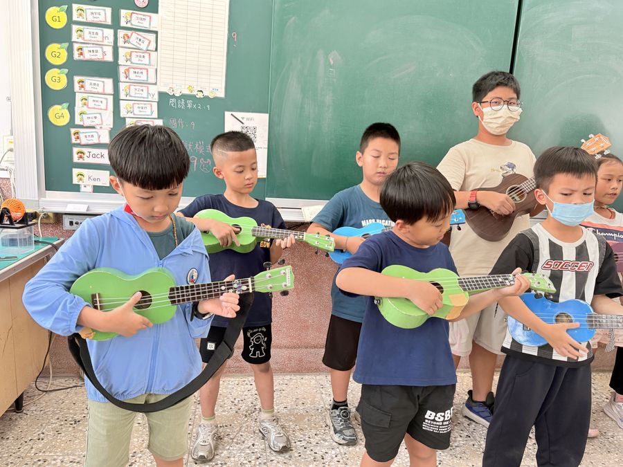 興華國小烏克麗麗社學生抱著彩色烏克麗麗合照 SingHua Ukulele Club students with their colorful ukuleles