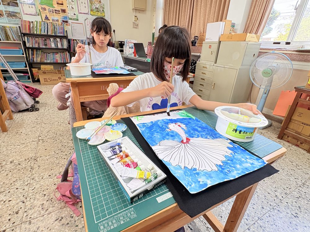 學生在教室裡專心畫水彩 A student concentrating on a watercolor painting in class