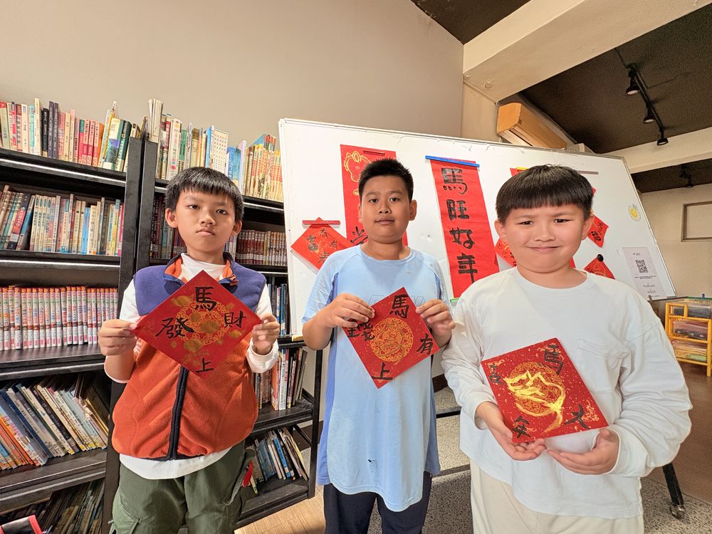 書法社學生拿著親手寫的紅色春聯合照 Calligraphy Club students holding up the red New Year couplets they wrote