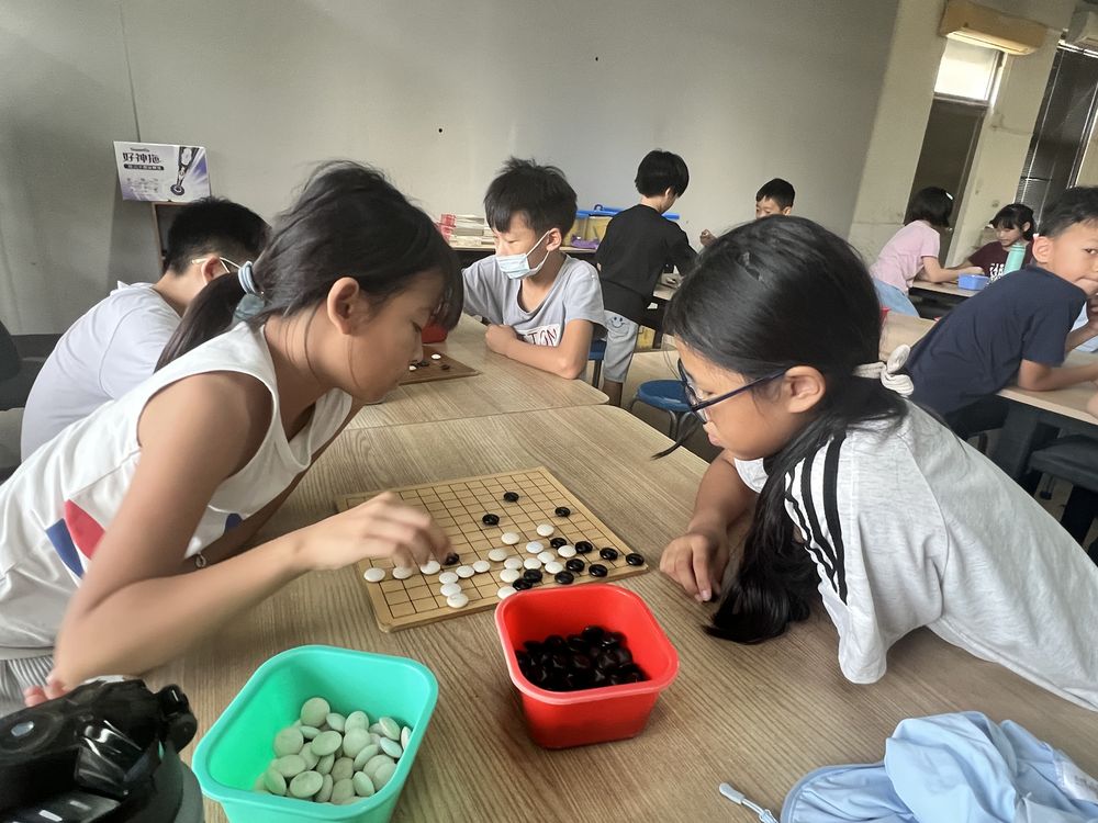 興華國小圍棋社兩位學生專心對弈 Two SingHua Go Club members concentrating on a game