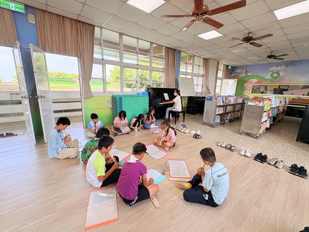 直笛社學生在教室地板上分組練習 Recorder Club students practicing in small groups on the classroom floor