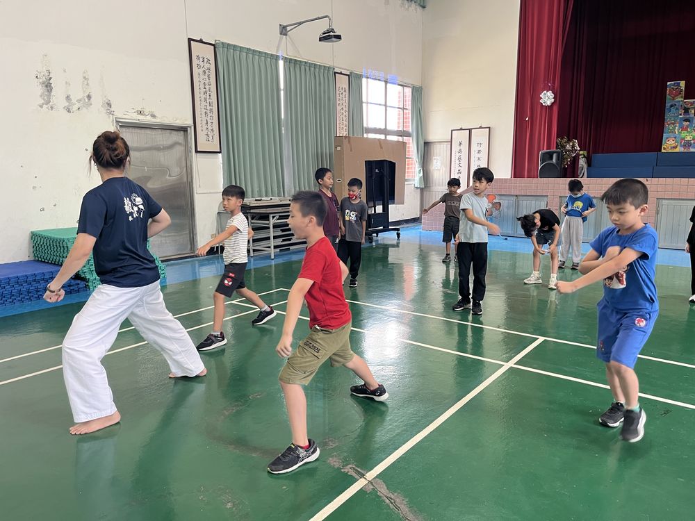 跆拳道社學生跟著教練一起練習動作 Taekwondo Club students practicing moves together with the coach