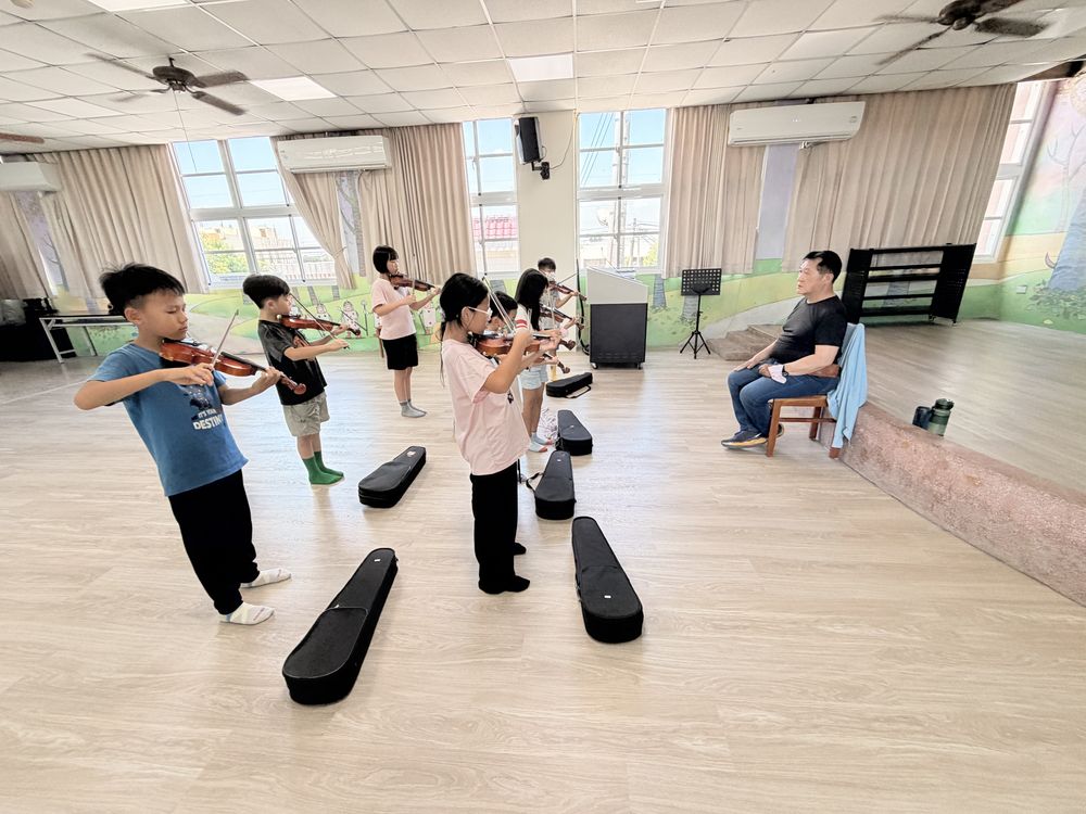 小提琴社學生在教室裡站著練琴 Violin Club students standing and practicing in a classroom