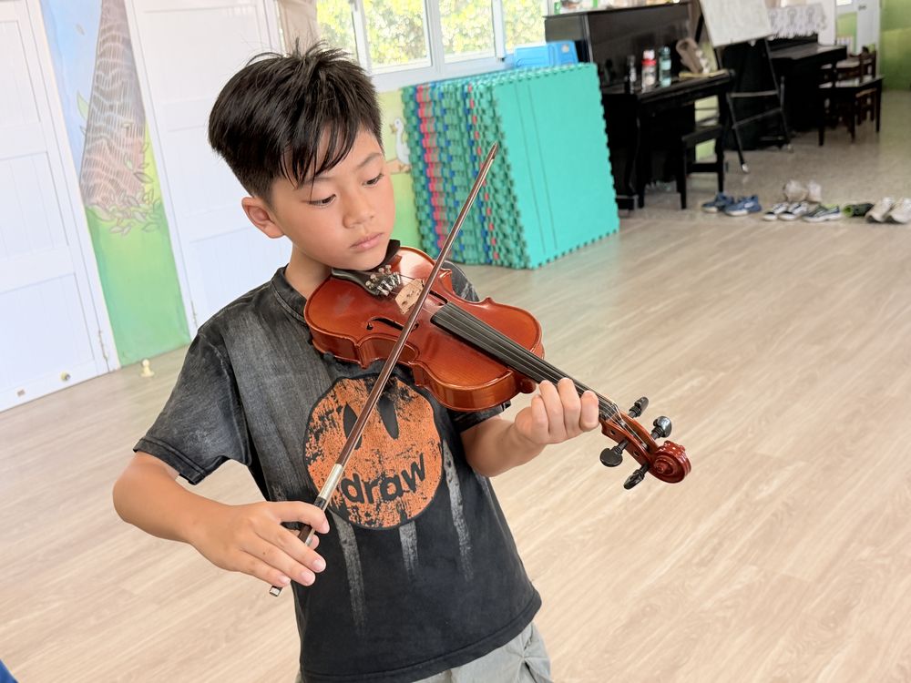 一位學生專心拉小提琴 A student concentrating on playing the violin