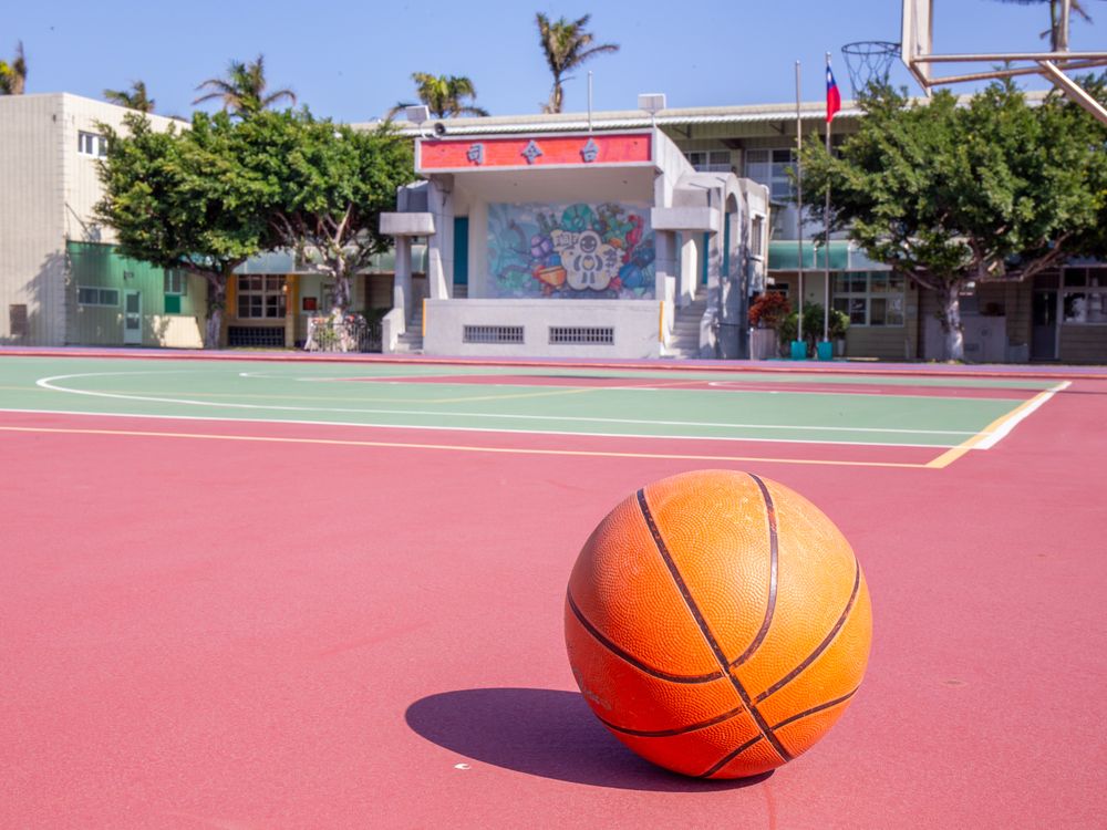 興華國小紅色籃球場上，擺著一顆巨大的籃球造型裝置 A giant basketball sculpture sitting on SingHua's red basketball court