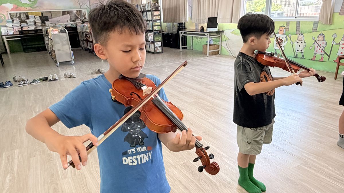 興華國小小提琴社的學生專心拉琴 A SingHua Violin Club student concentrating on playing