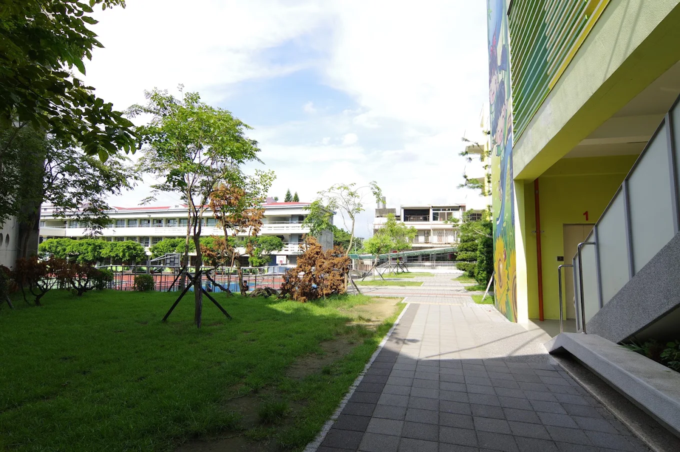 A green lawn and walkway between Tachu's classroom buildings 大竹國小教學樓間的草坪與步道