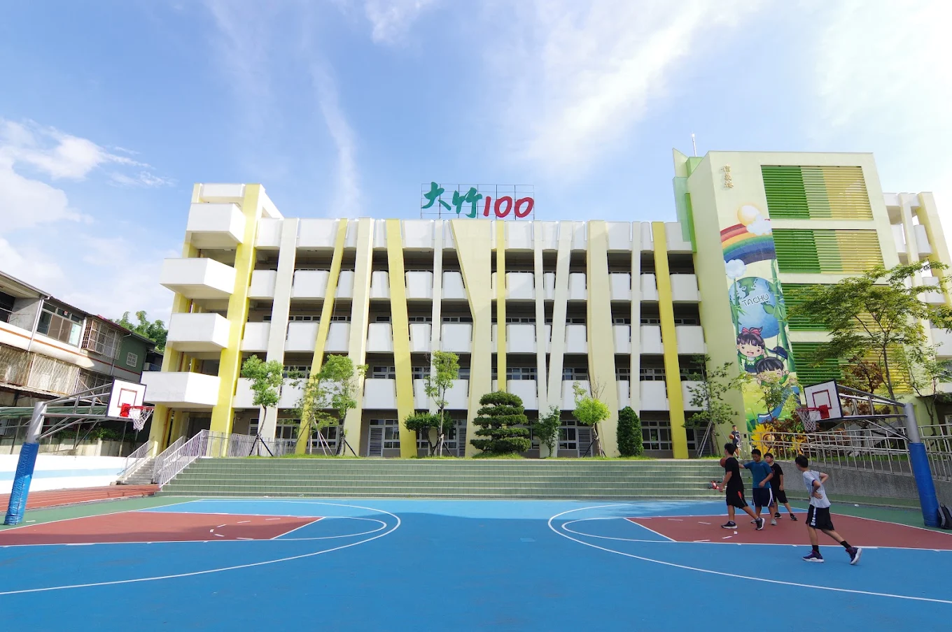 Tachu's Tachu-100 building with students playing basketball 大竹國小「大竹100」大樓與籃球場