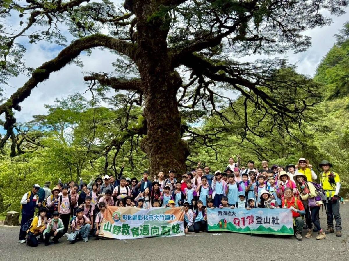 Tachu students and teachers on a mountain-education hike, gathered beneath a giant tree 大竹師生山野教育登山活動，於大樹下合影