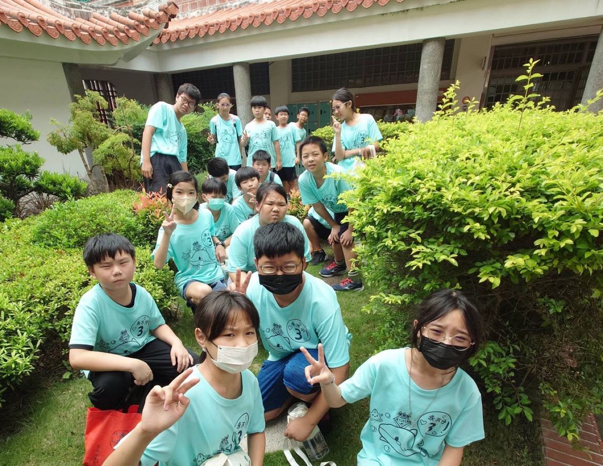 Tachu students on a field trip posing together in a green garden courtyard 大竹學生戶外教學於綠意庭園合影
