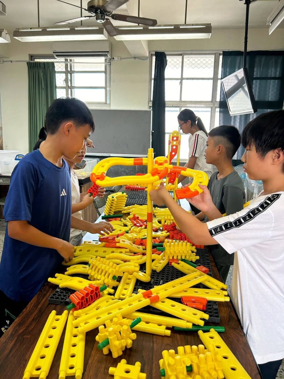 村上國小暑期營學生合力組裝黃色積木軌道