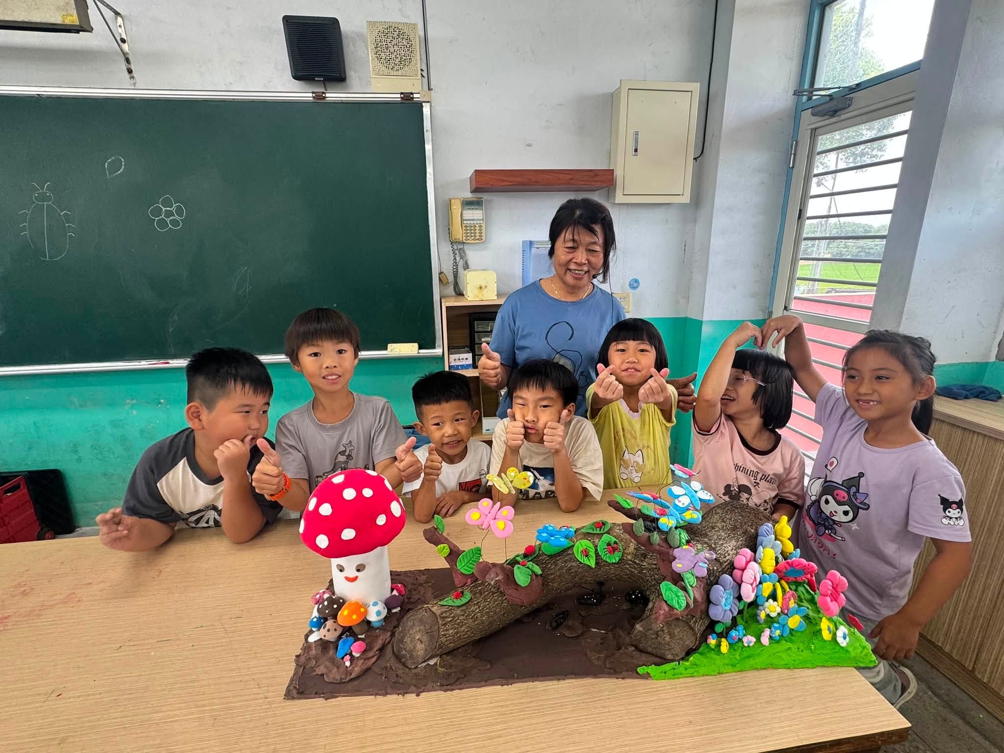 孩子們與完成的昆蟲微型森林作品合影