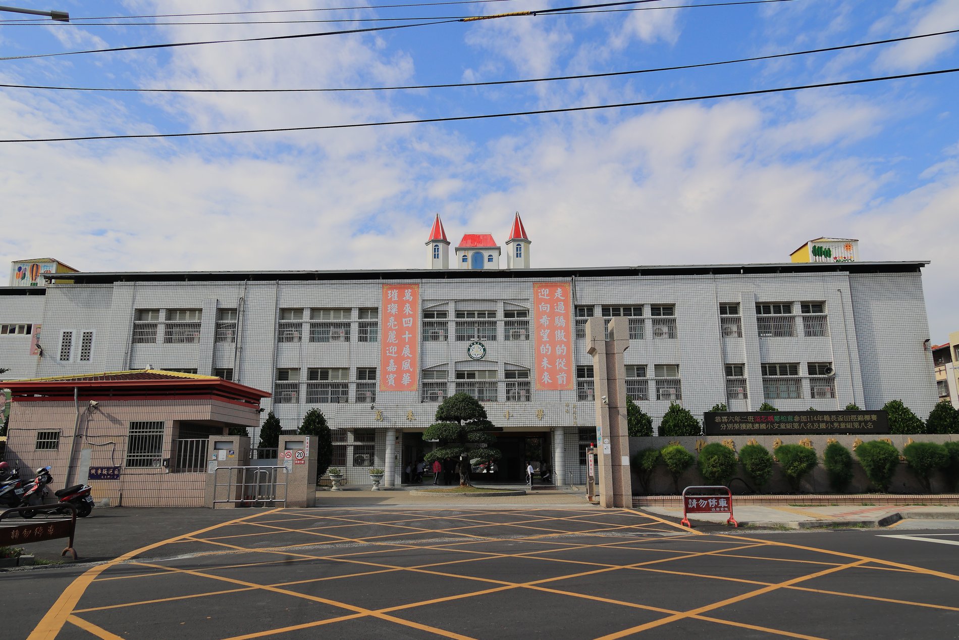 Wanlai Elementary School main building under a blue sky · 萬來國小主校舍