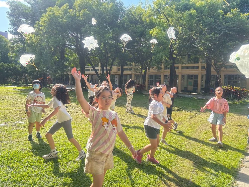 萬來學生在草地上開心玩降落傘