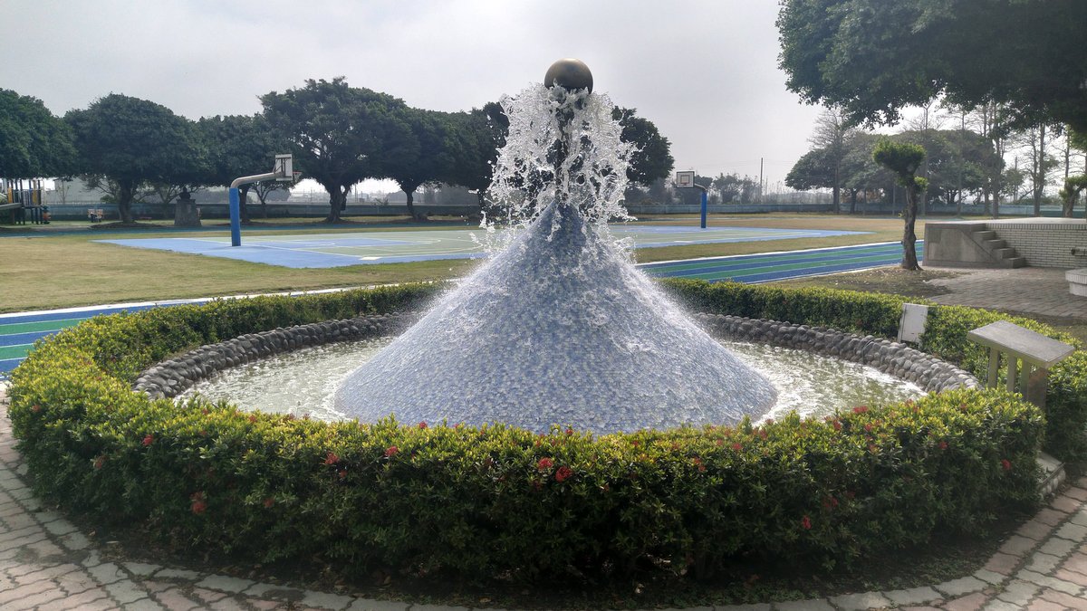 Wenchang Elementary School central fountain with surrounding green hedges