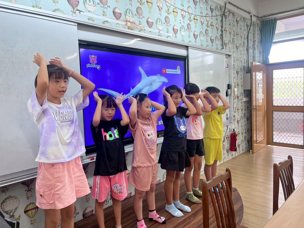 Students acting out an English class with an interactive screen