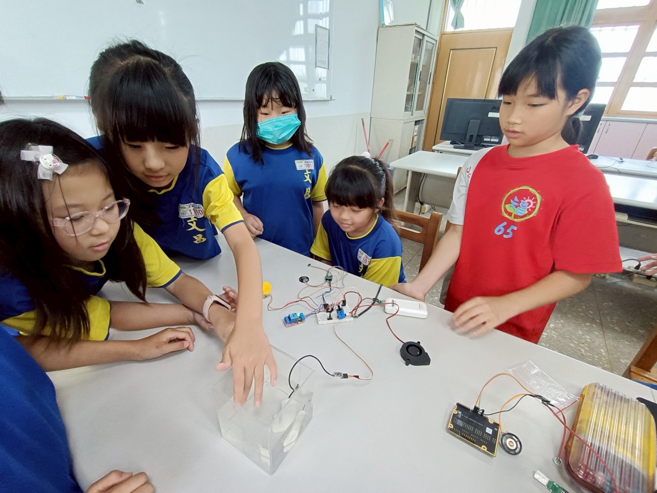 Students gathered around a micro-controller circuit project