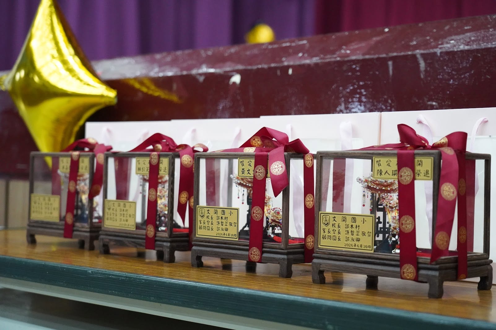 Framed keepsake gifts for the four retiring teachers, engraved with their names