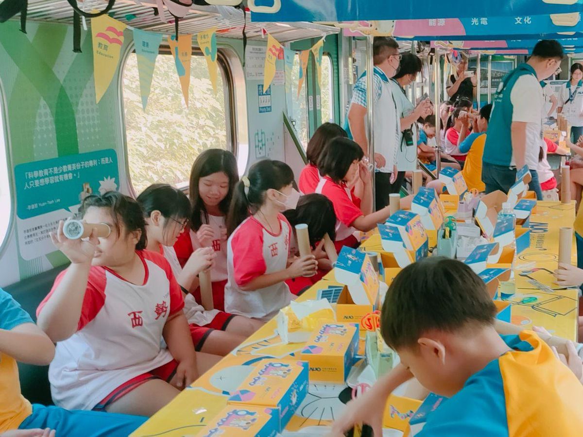 學生在火車車廂裡製作並試看萬花筒