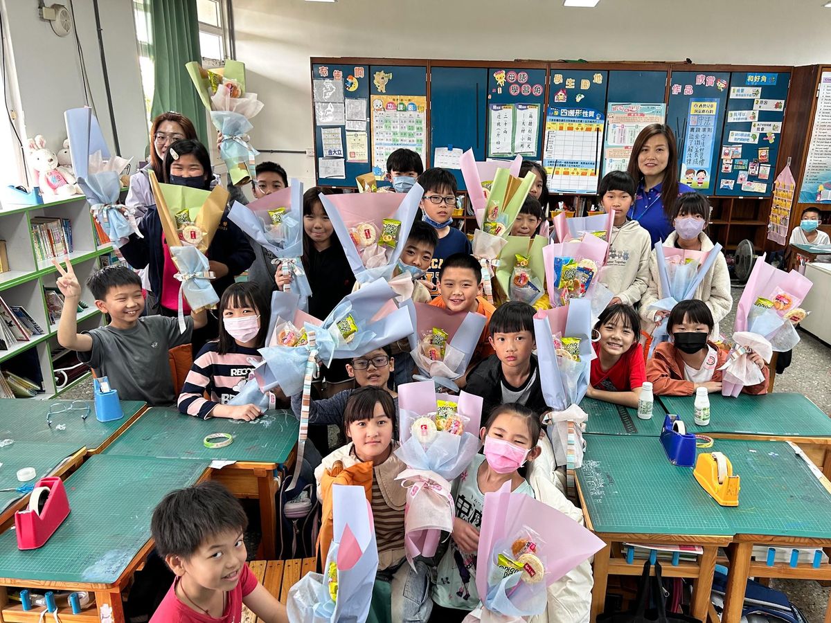 學生在教室裡舉起和志工媽媽一起做的餅乾花束