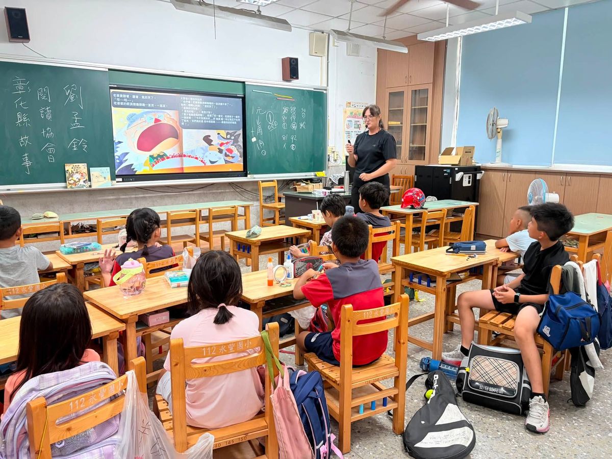 A storyteller shares a picture book on the big screen