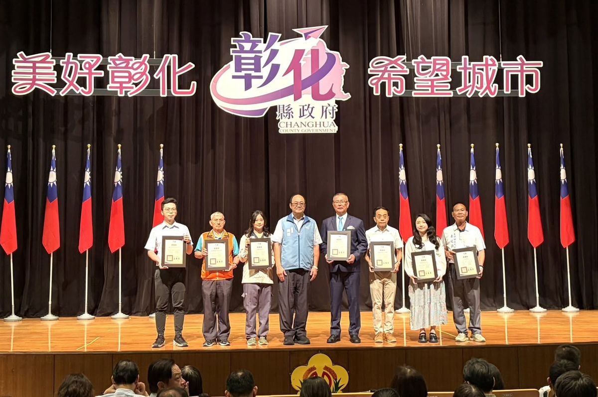彰化縣政府「美好彰化 希望城市」頒獎典禮舞台上，受贈單位代表手持感謝狀合影，背景是國旗 Representatives holding certificates of thanks on stage at a Changhua County Government award ceremony