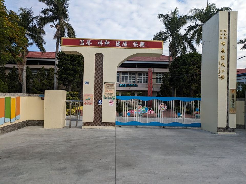 源泉國小校門，門楣上寫著「溫馨 祥和 健康 快樂」，門柱標示「彰化縣二水鄉源泉國民小學」 The Yuanchyuan front gate, its arch reading 'warm, harmonious, healthy, happy' and its pillar carrying the school's name