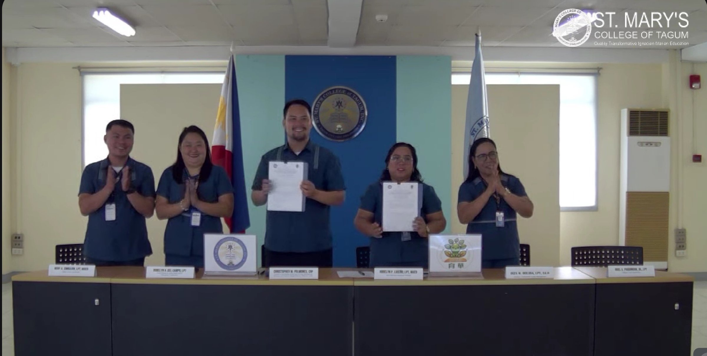 The St. Mary's College of Tagum delegation holding up the signed MOU documents during the virtual signing ceremony with Yuhua Elementary on November 14, 2025