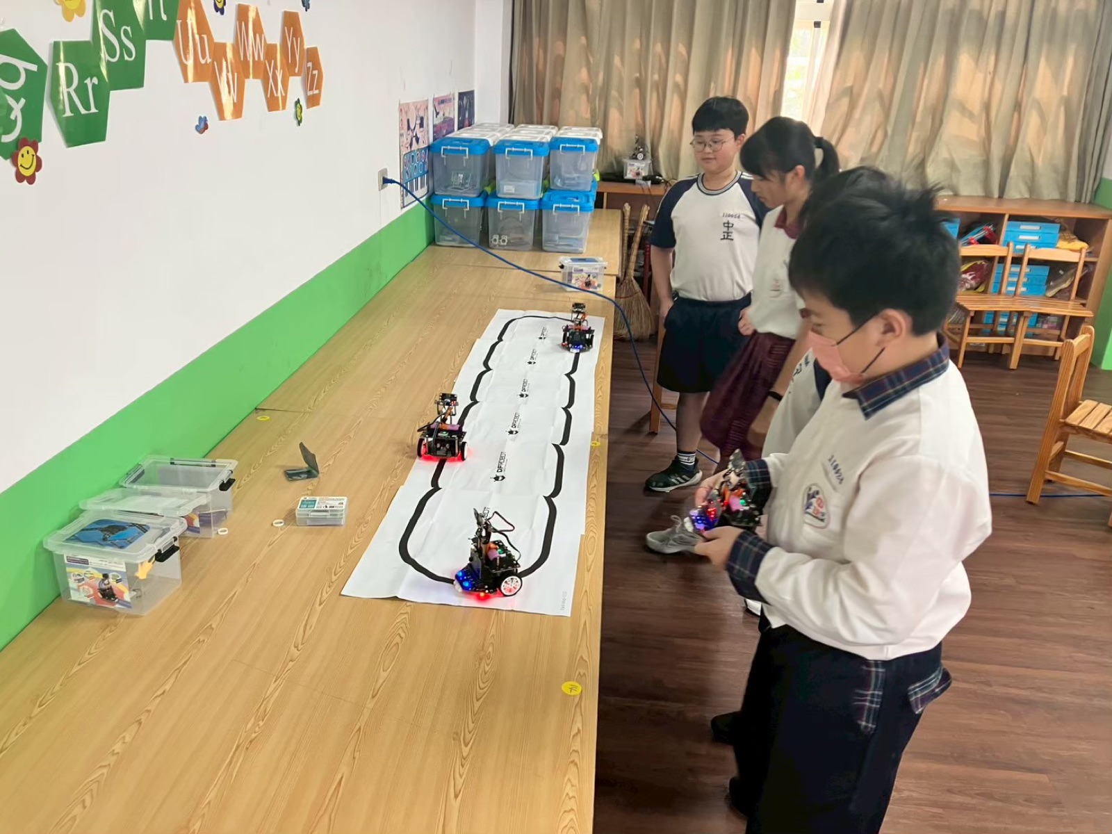 Zhongzheng Maker Club students running line-following robots on a track